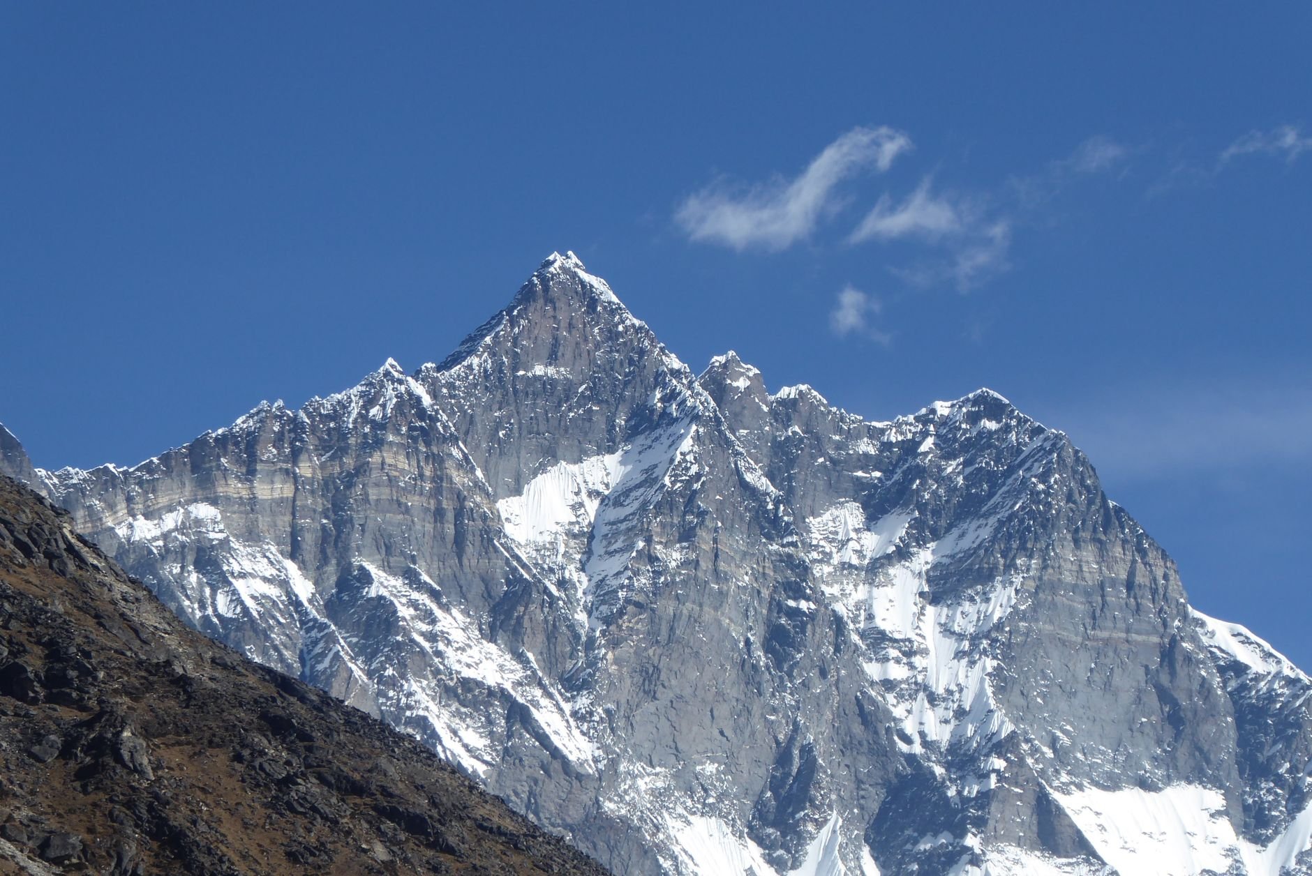 Captivating view of Mount Lhotse, showcasing its majestic snowy peaks under a clear blue sky in Nepal.